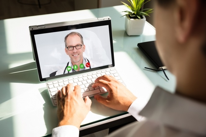 patient on laptop with doctor on screen through a online call