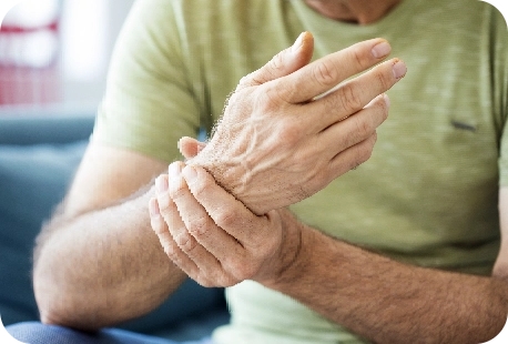 an older man holding his wrist.