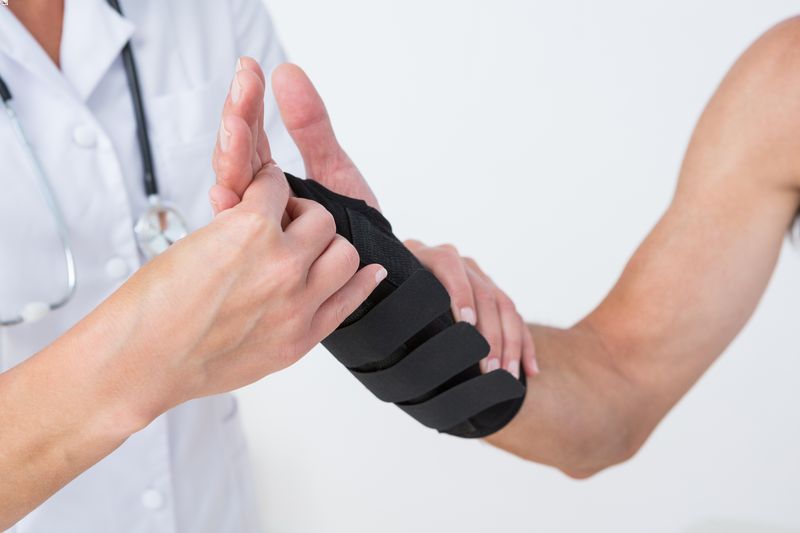Doctor checking wrist fracture in a brace